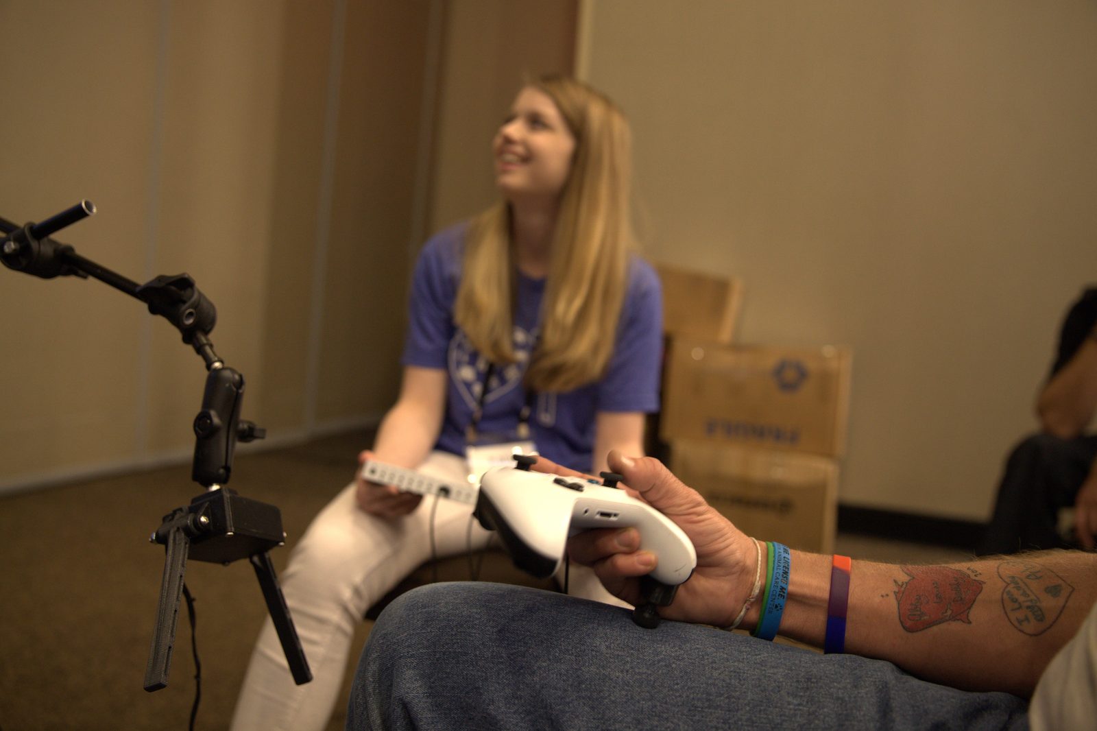 An occupational therapist sits alongside a client during a one-on-one adaptive-gaming session.